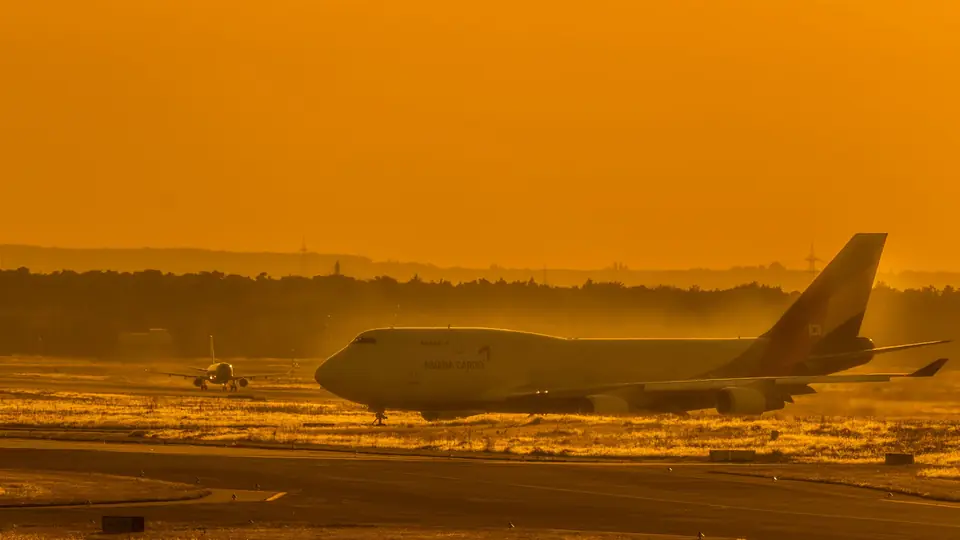 A cargo plane on the runway at sunset