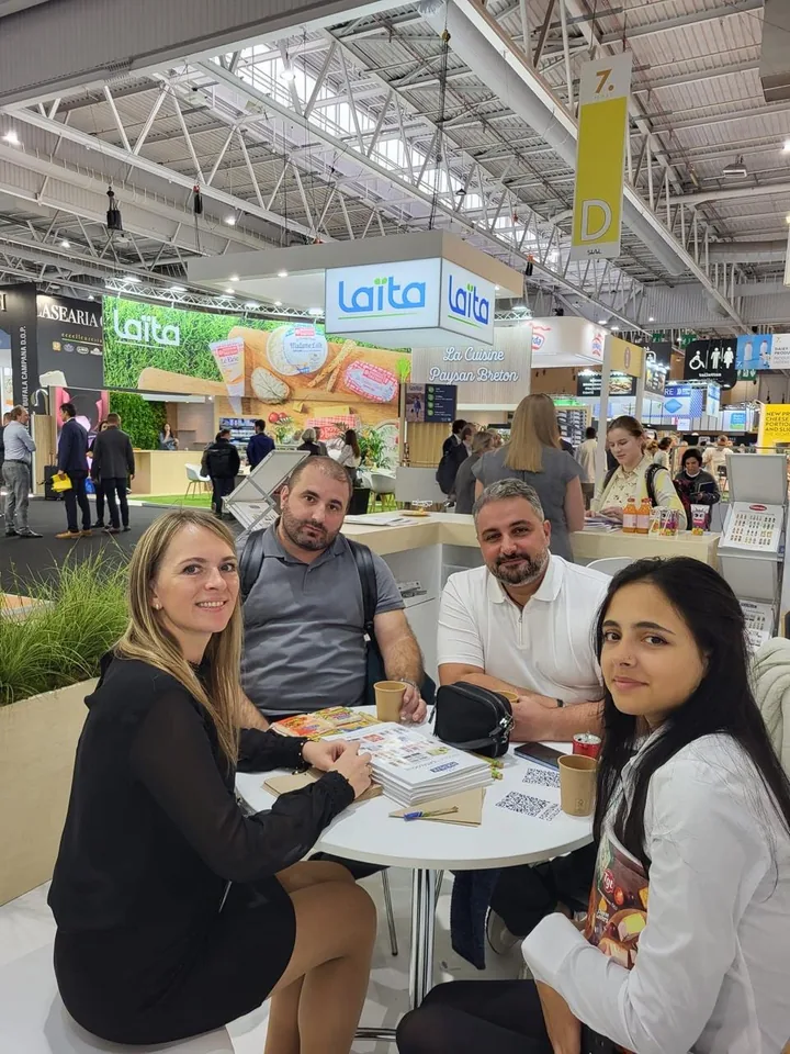 Buyers and VLC staff in a meeting over product catalogues at a trade fair stand